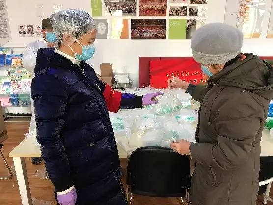 為樓棟分發(fā)口罩，并為包裝袋消毒